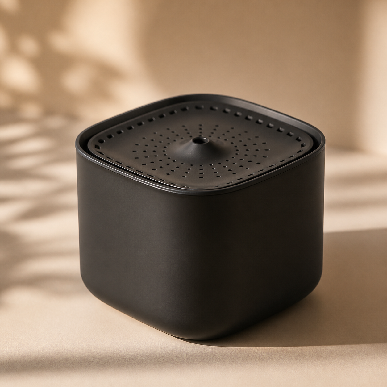 Miauva Drinking Fountain in matte black on a warm beige surface